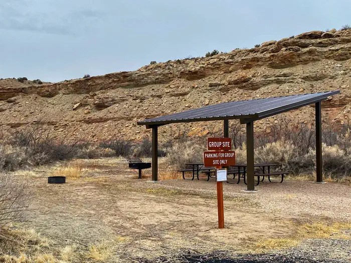 Westwater Group Site picnic tables underneath shade shelter and sign.