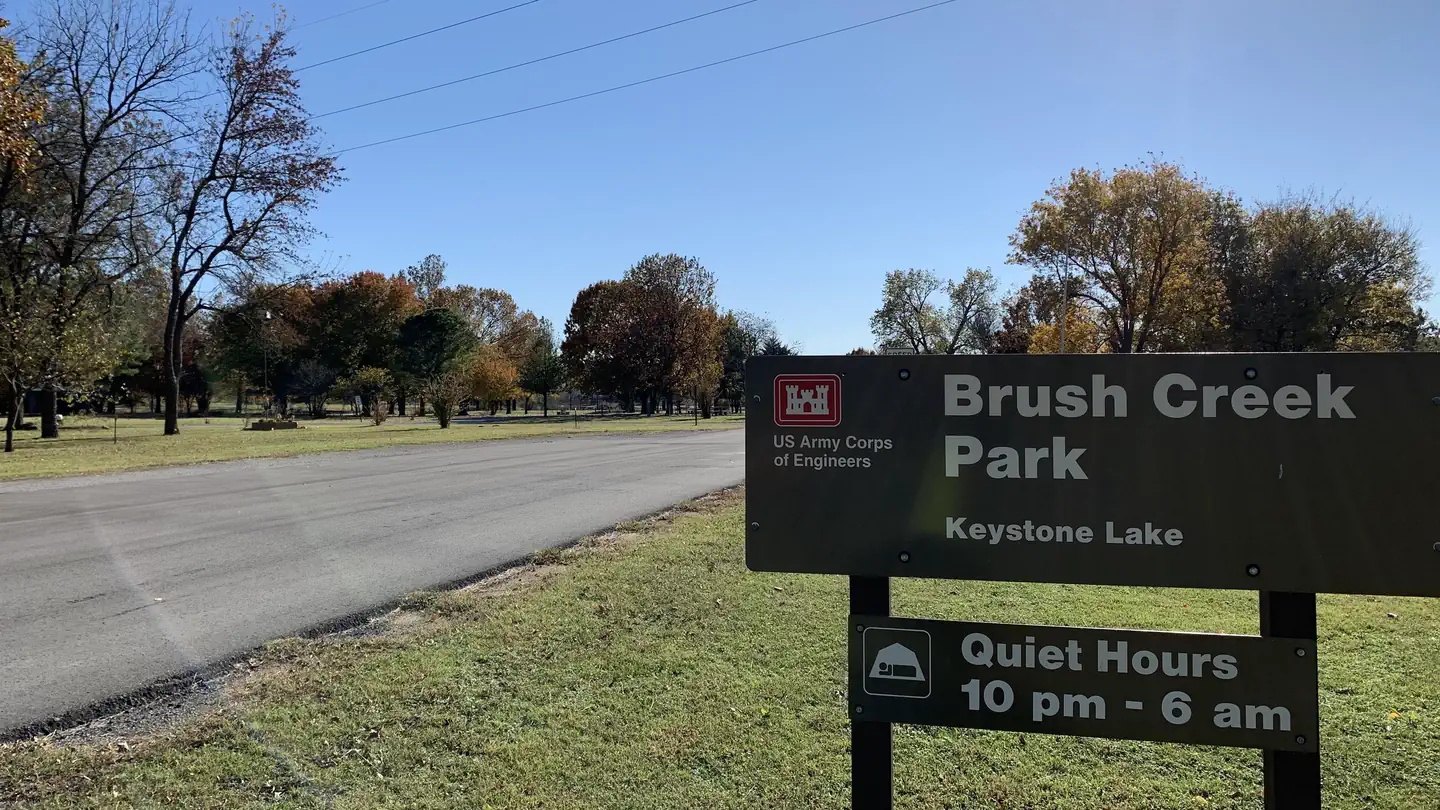 Brush Creek park sign and entrance road to campground at Keystone Lake.