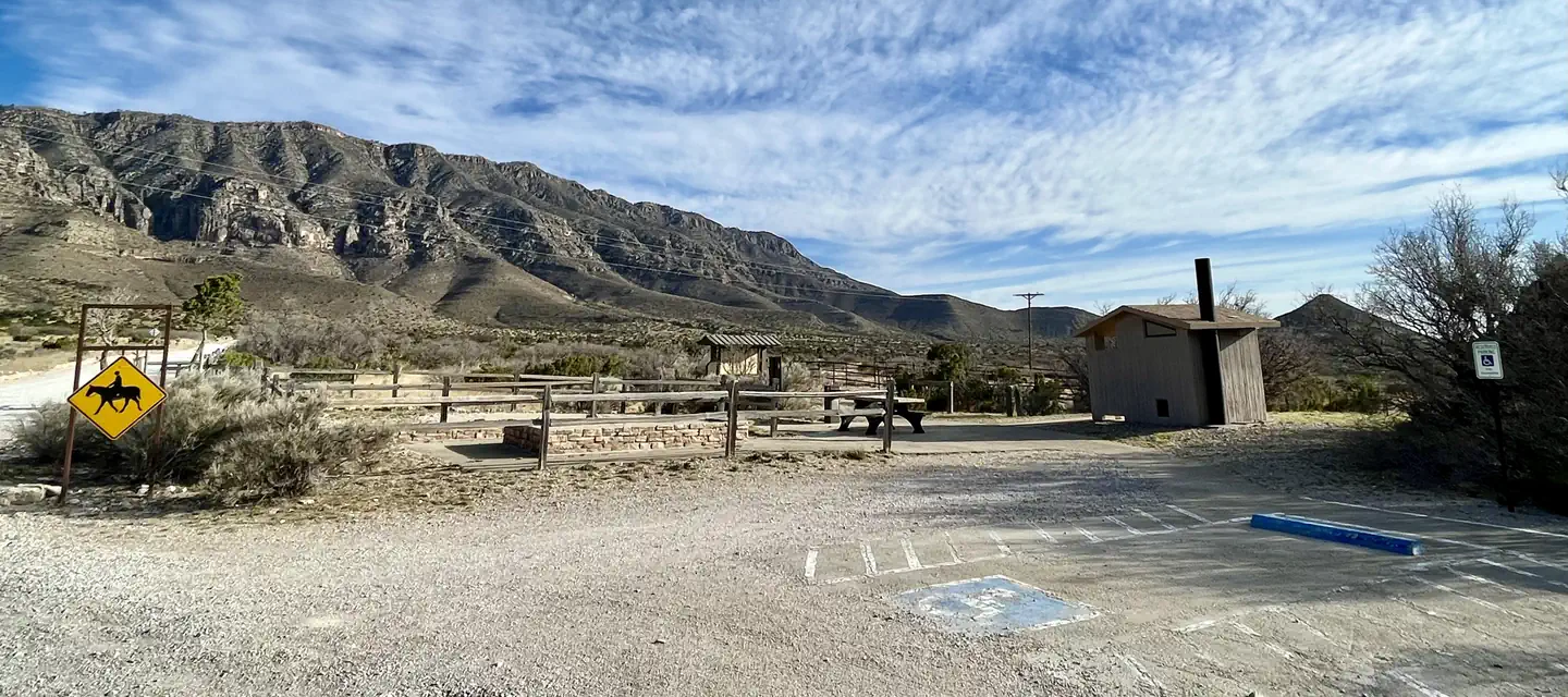 Frijole Horse Corral Campsite with RV parking spaces in the foreground, tent pads, picnic table and restroom are shown.