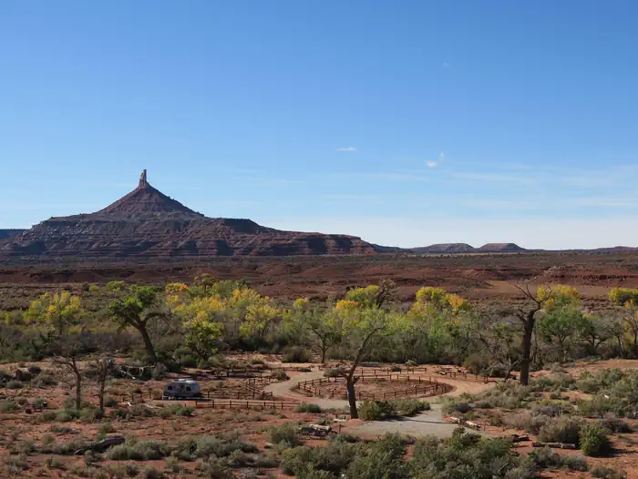 Panoramic view of the desert campground with a ribbon of cottonwood trees and Six Shooter Peak in the background.