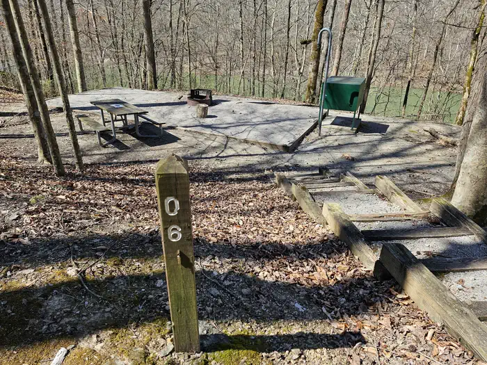 Brown post with number 06 stands in front of campsite.