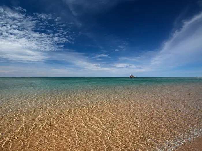 View of the beach and Morazan Shipwreck in the distance under a blue sky from South Manitou Island