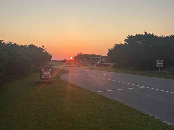 Sun rising over Ocracoke Campground capturing sunrays streaming over A Loop campsites on exterior perimeter of campground