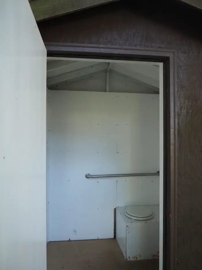 Interior of outhouse at Steamer Bay Cabin with hand rail