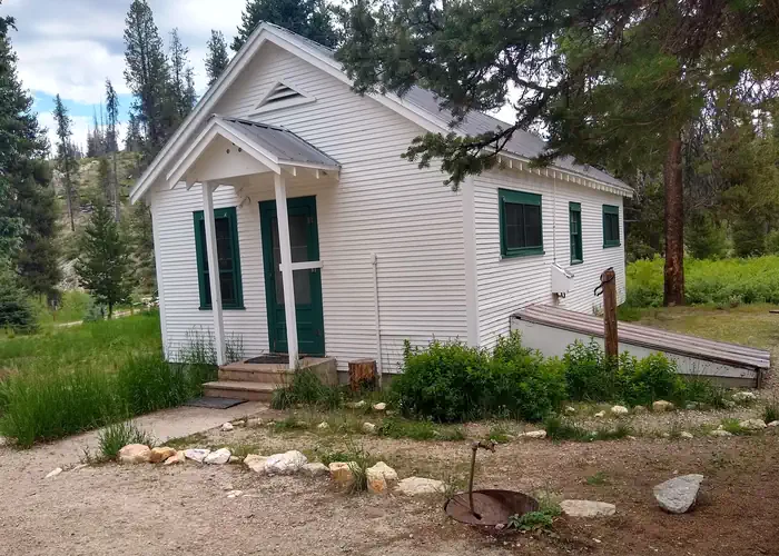 A white cabin in the woods.