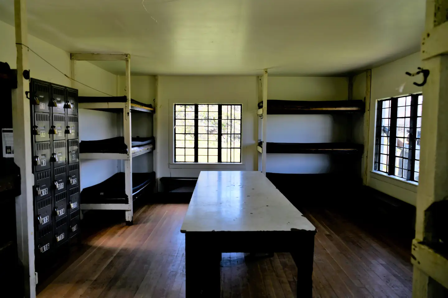 interior view of cabin showing stacked bunks, table, and lockers.