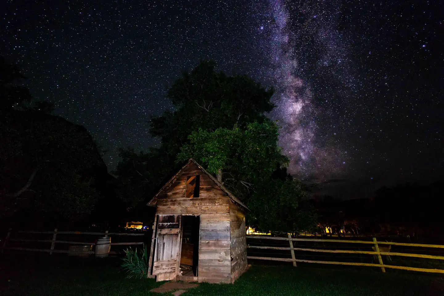 A purple starry night sky is featured behind a small building.