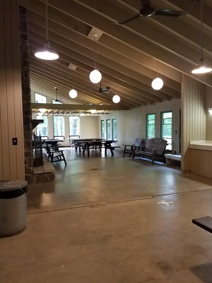 Inside of Clark Lake pavilion showing room layout with benches and picnic tables.