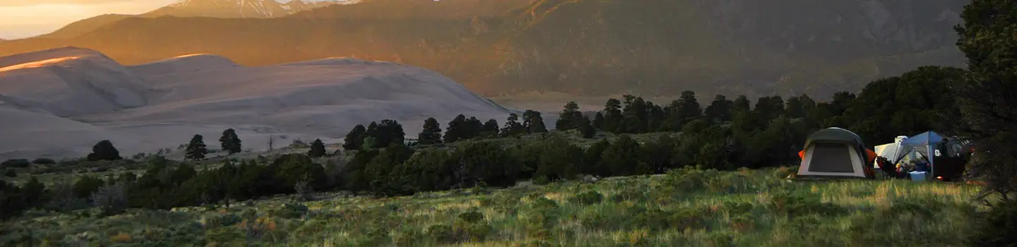 Pinon Flats Campground, tent on the right with sand dunes on the left.
