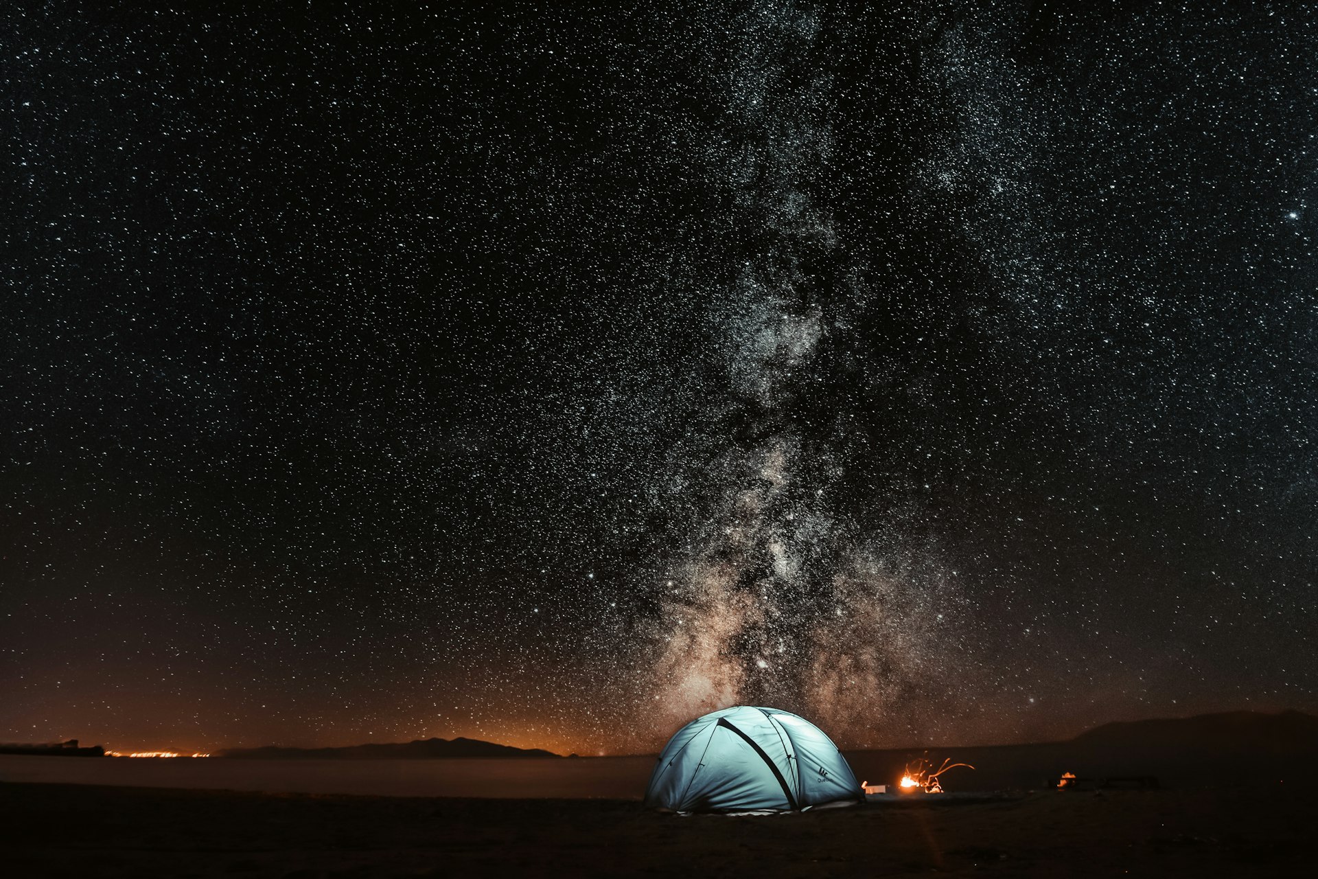 Blue tent glowing under the Milky Way